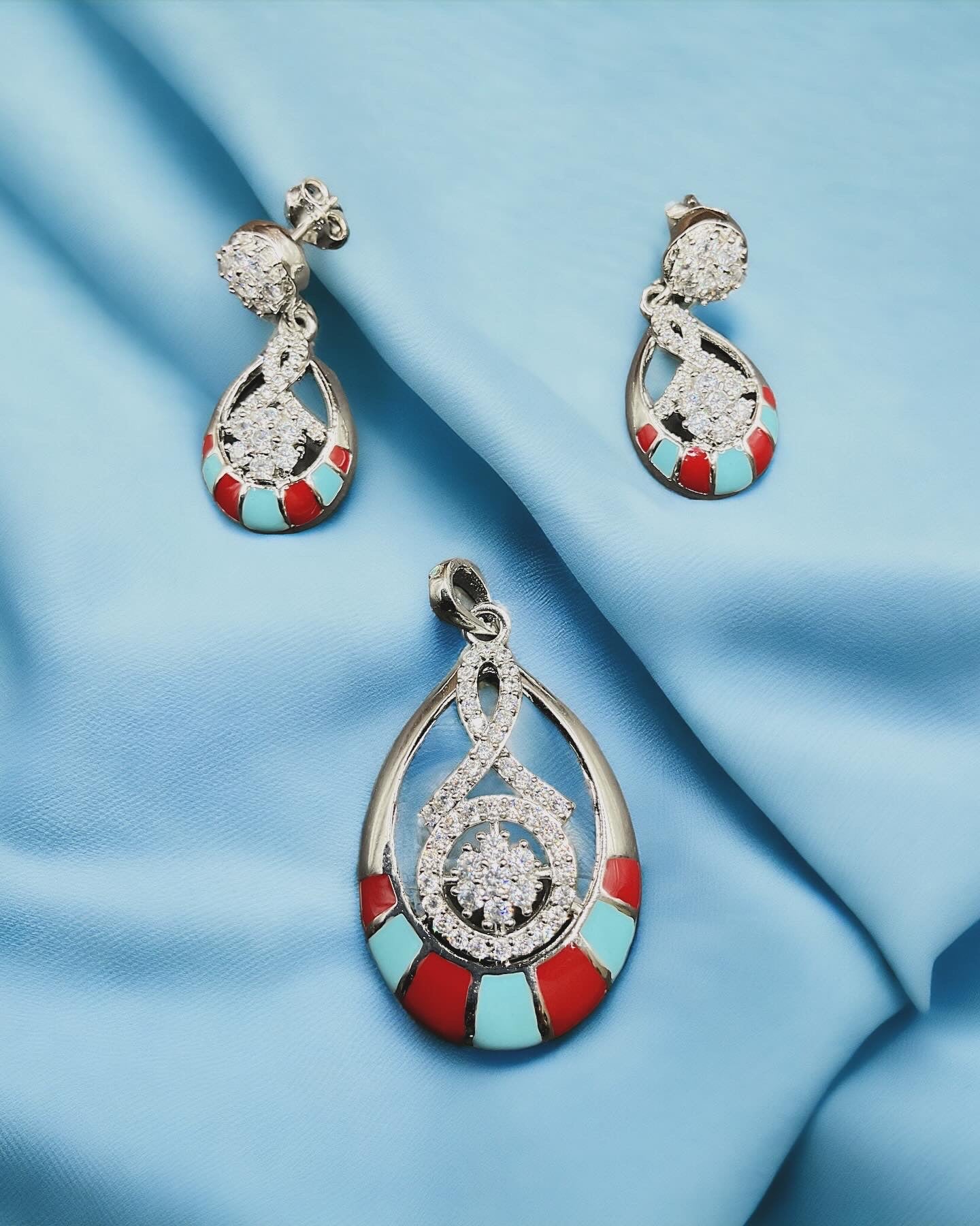 a pair of earrings on a blue cloth