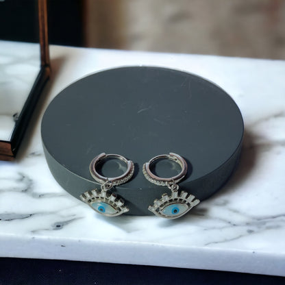 a pair of earrings sitting on top of a marble counter