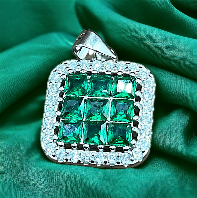 a green and white diamond pendant on a green cloth