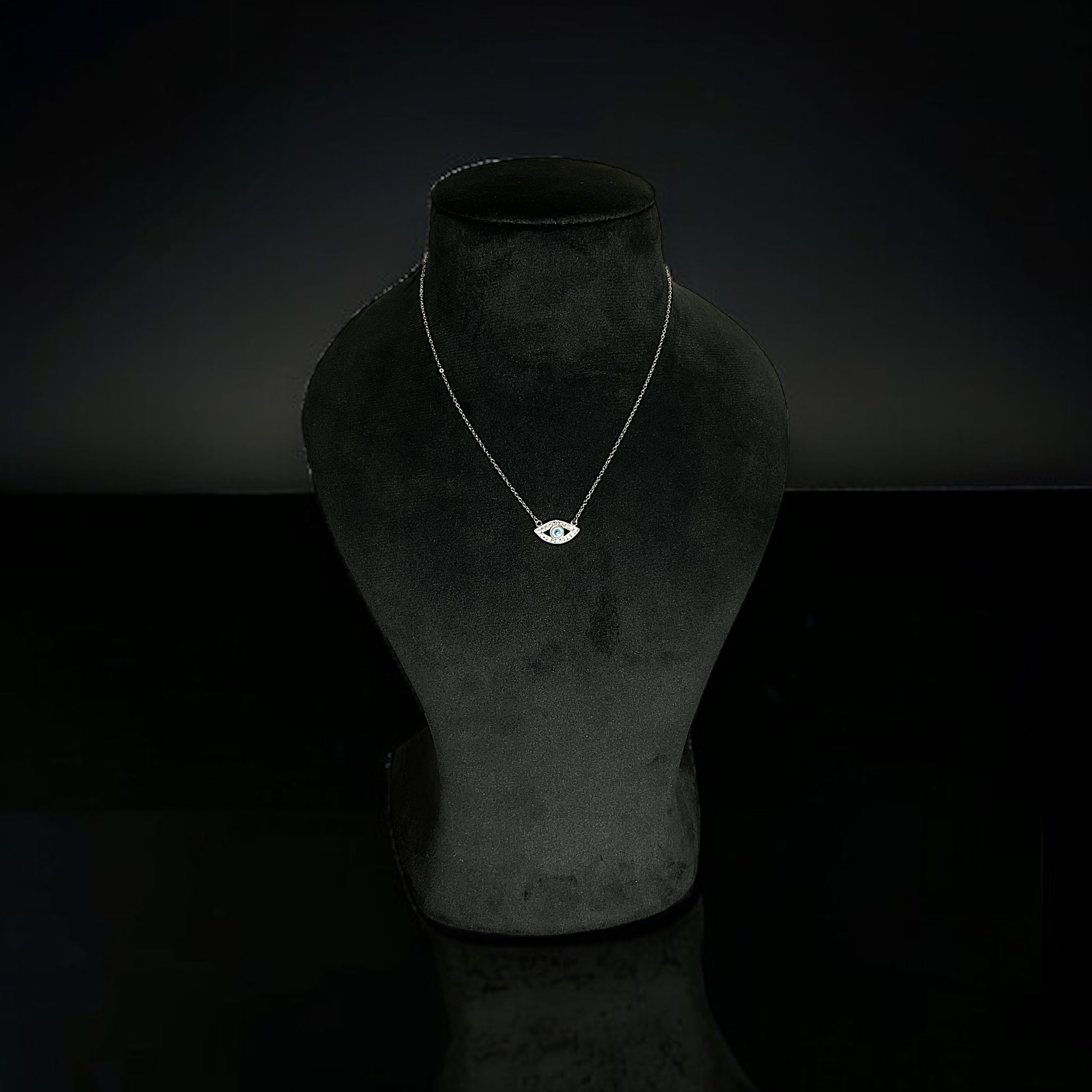 a necklace on a mannequin with a black background