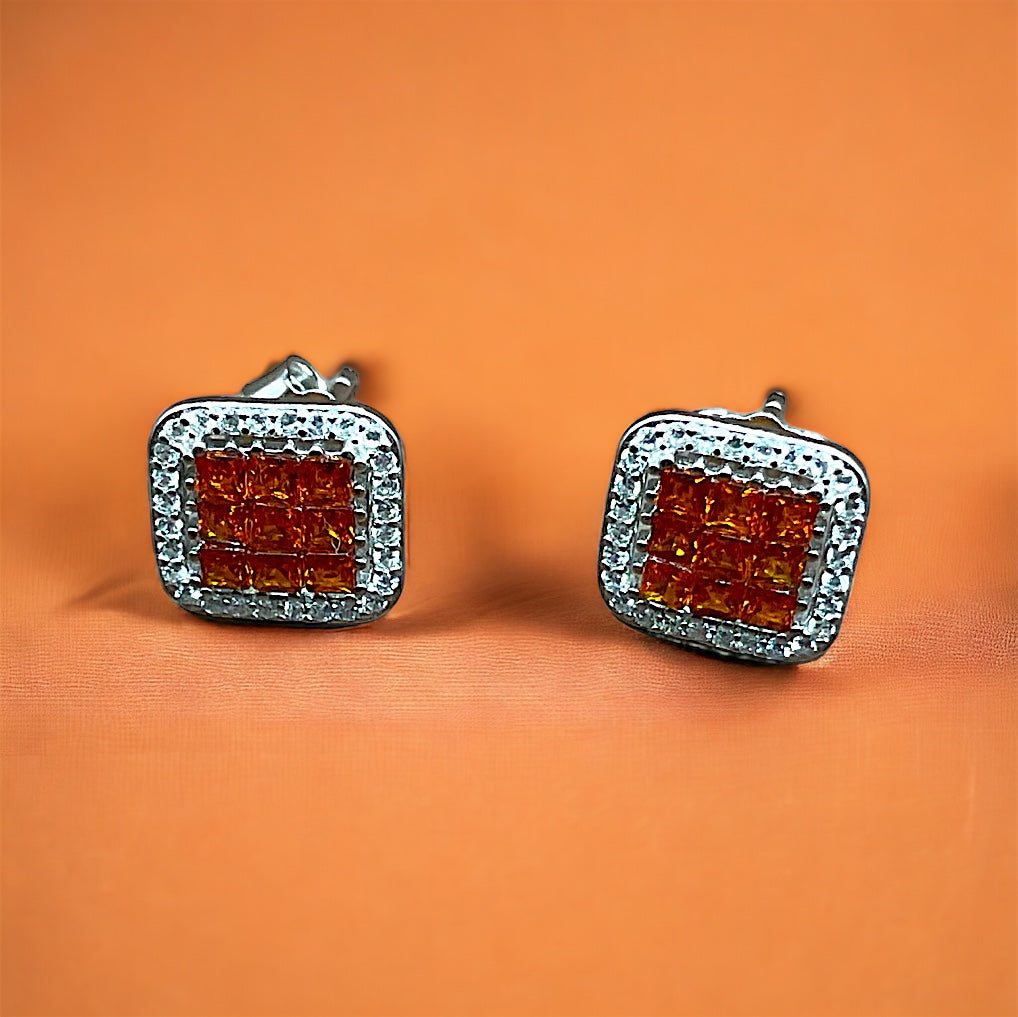 a pair of red and white diamond earrings