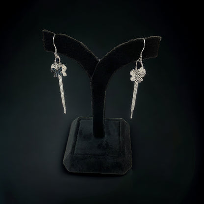 a pair of earrings is displayed on a stand