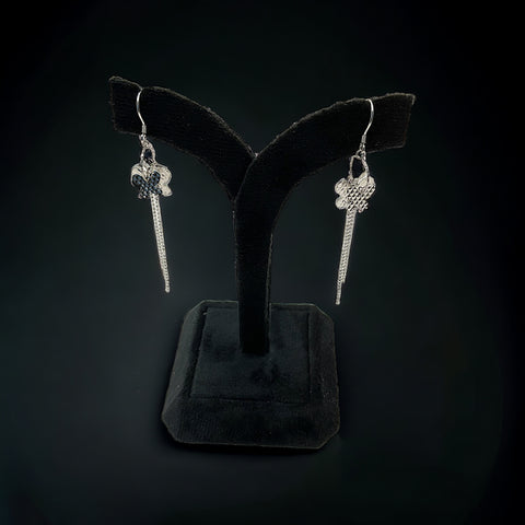 a pair of earrings is displayed on a stand