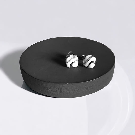 a pair of earrings sitting on top of a black box