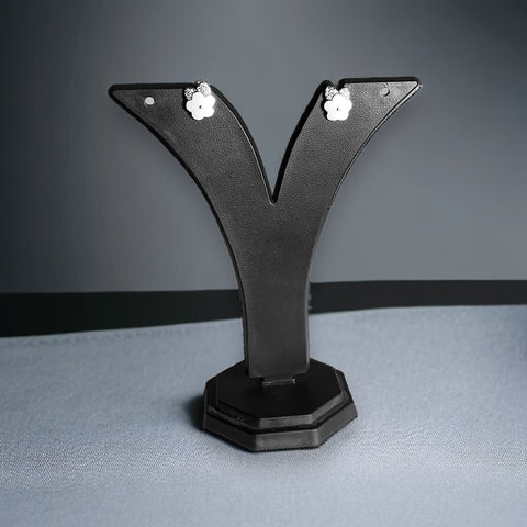 a pair of earrings is placed on a black stand