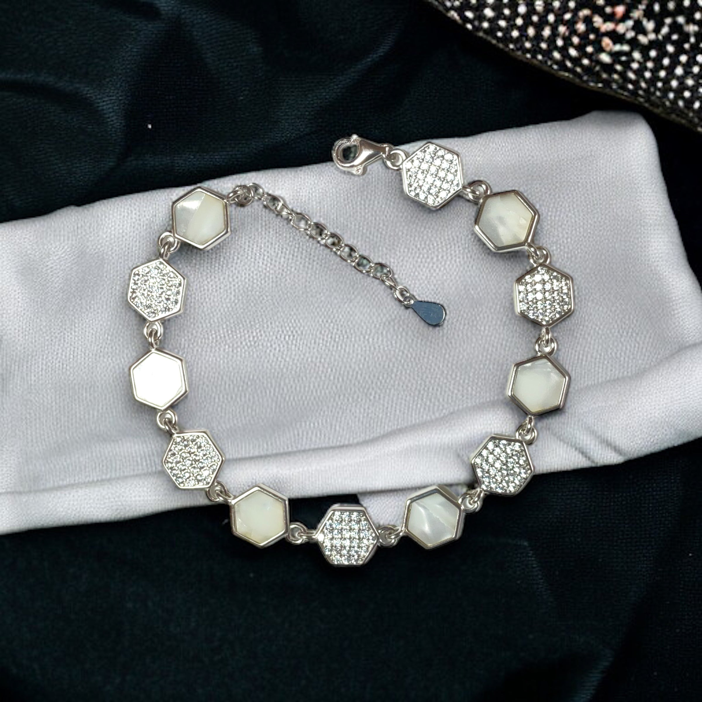 a silver bracelet with white stones on it