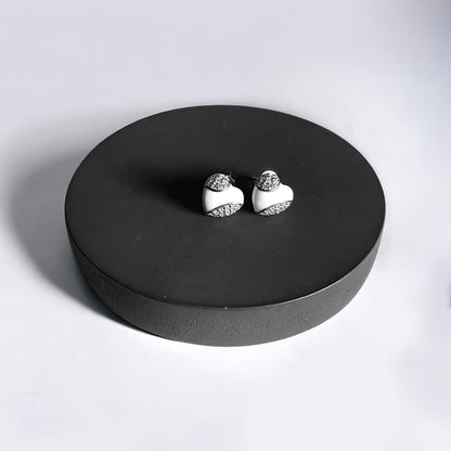 a pair of earrings sitting on top of a black box