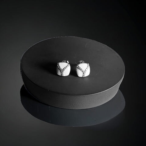 a black and white photo of a pair of earrings