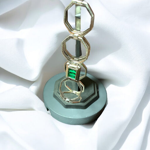 a ring is sitting on a stand on a white cloth