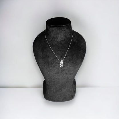 a black and white photo of a necklace on a mannequin