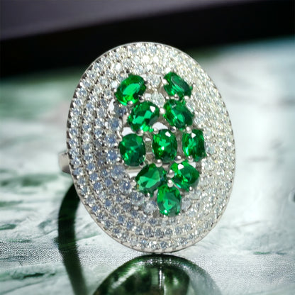 a close up of a ring with green stones