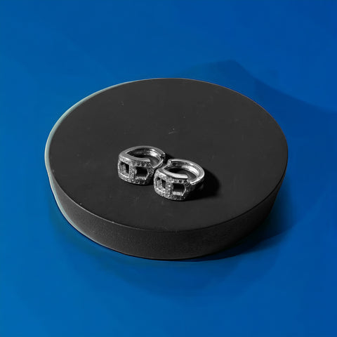 a couple of silver rings sitting on top of a blue surface