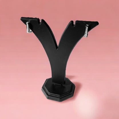 a pair of black metal brackets on a pink background