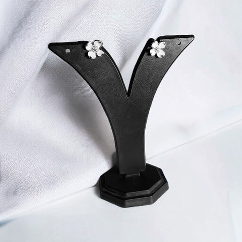 a pair of black earrings with white flowers on them