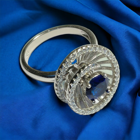 a diamond and sapphire ring on a blue cloth