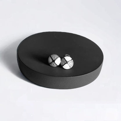 a pair of earrings sitting on top of a black box