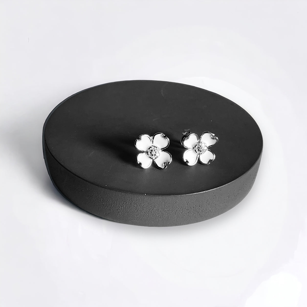 a pair of white flowers sitting on top of a black plate