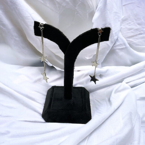 a pair of black earring stands on a white sheet