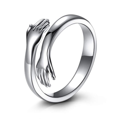 a silver ring with two hands on it