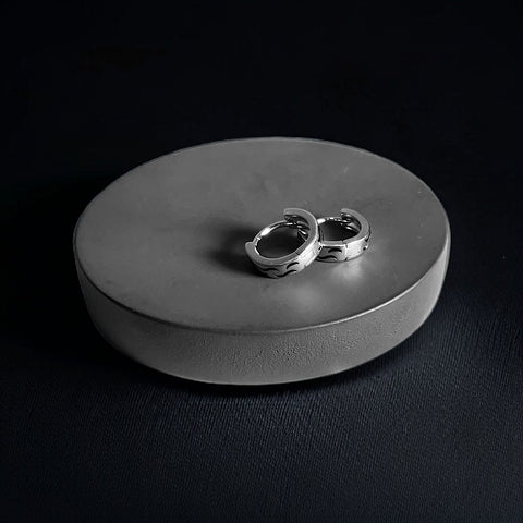 a couple of silver rings sitting on top of a metal tray