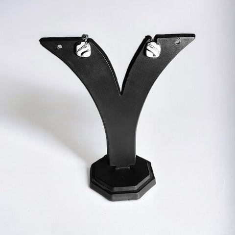 a pair of black earrings on a black stand