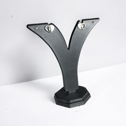 a pair of black and silver earrings on a black stand