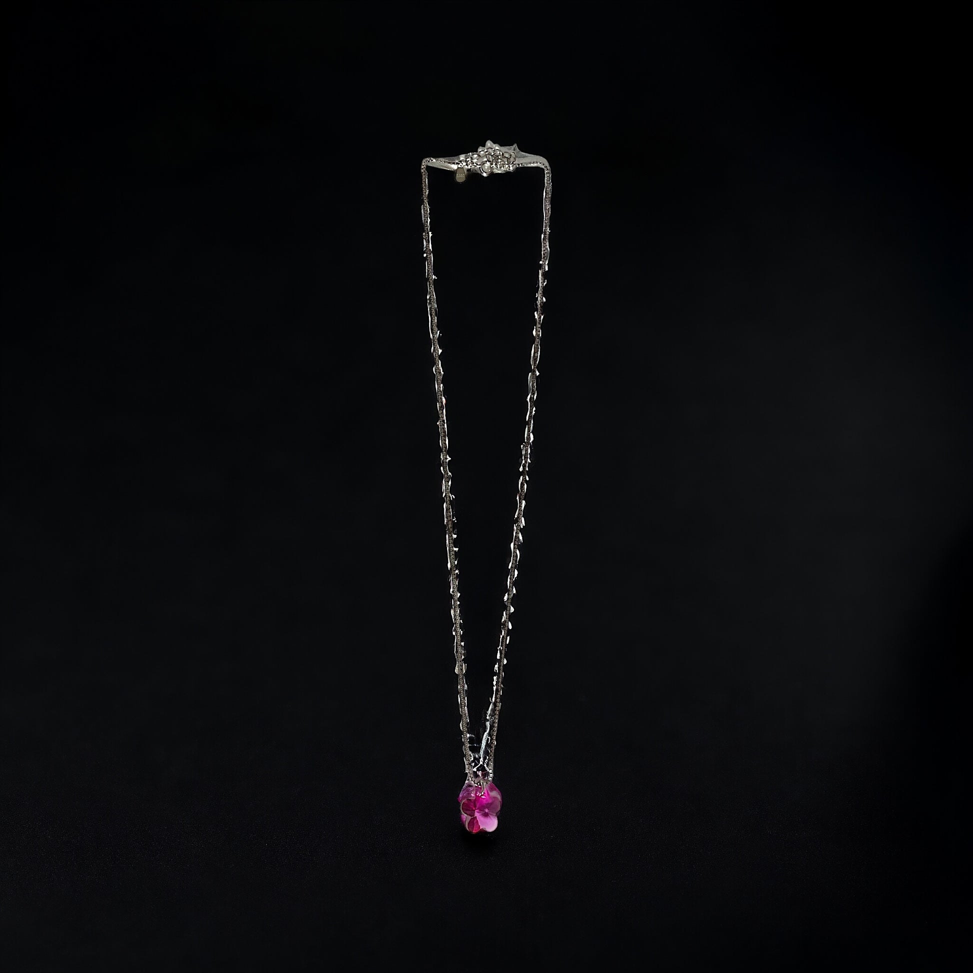 a necklace with a pink stone hanging from it