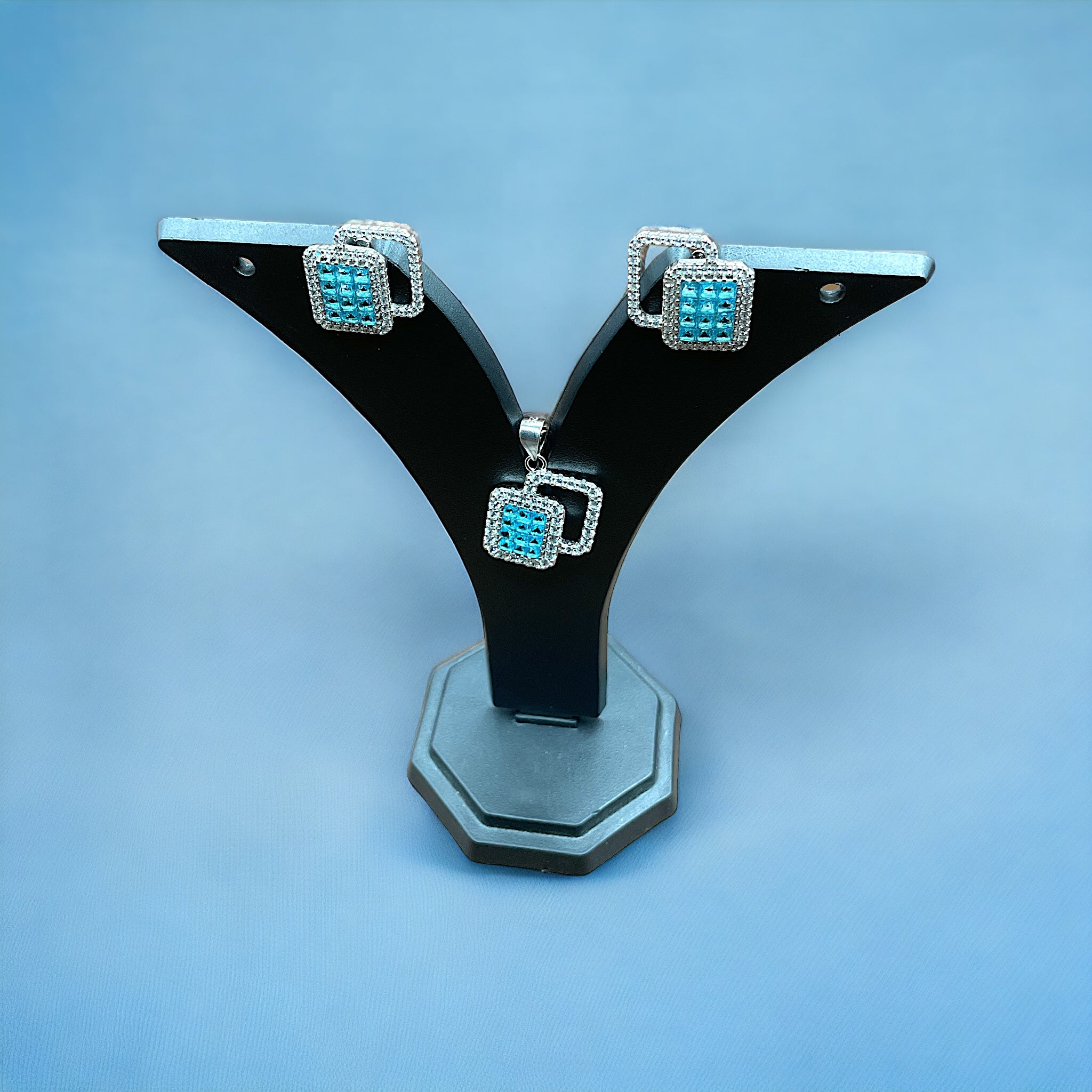 a pair of black and blue earrings on a stand