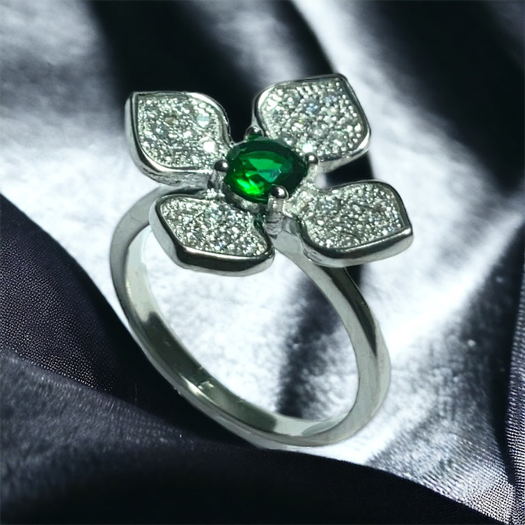 a close up of a ring with a green stone