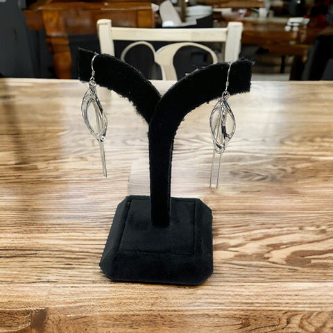 a pair of black earring stands on a wooden table