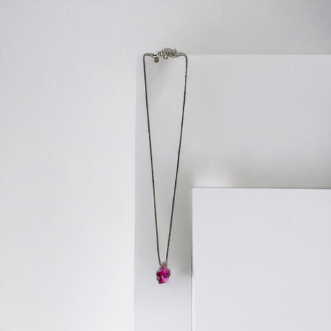 a necklace with a flower hanging from it