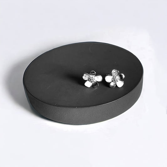 a pair of earrings sitting on top of a black box