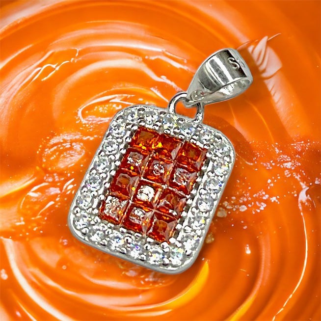 a square pendant with a red square surrounded by white diamonds