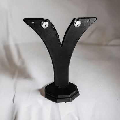 a pair of black earrings on a black stand