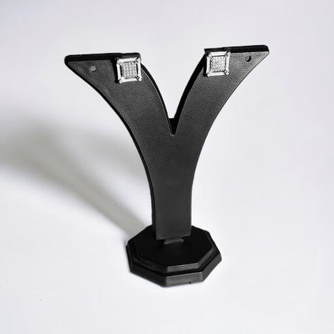 a pair of diamond earrings on a black stand