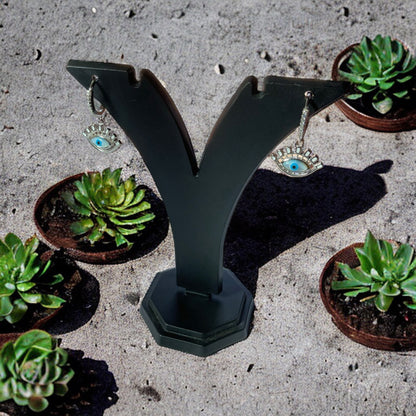 a pair of earrings sits on top of a sculpture