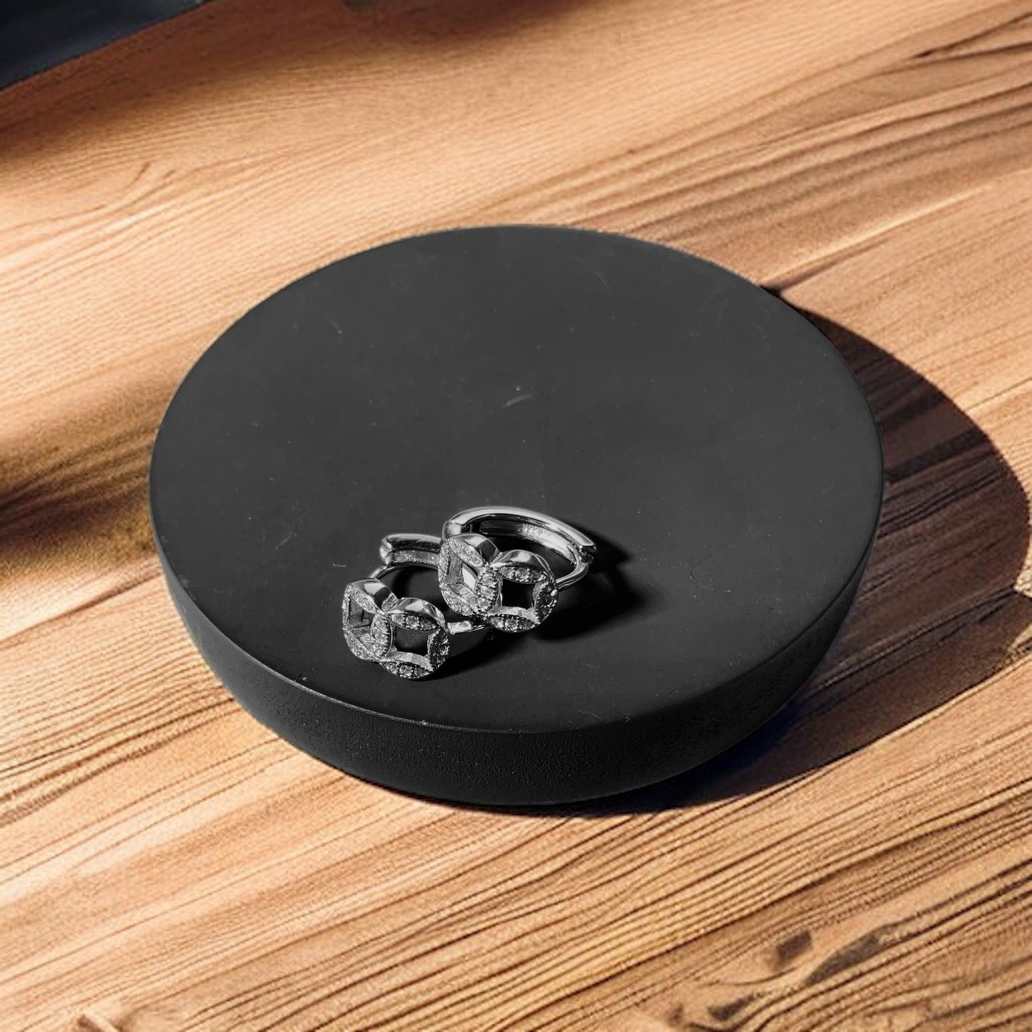 a pair of earrings sitting on top of a wooden table