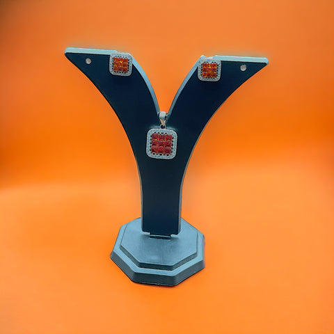 a close up of a pair of earrings on an orange background