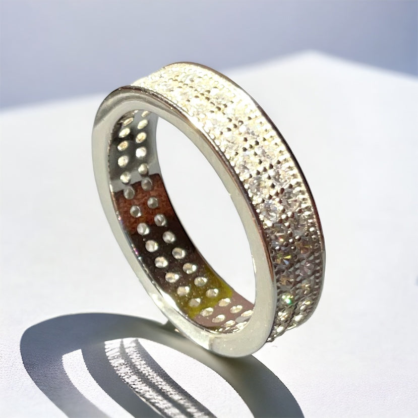 a silver ring with dots on it sitting on a white surface