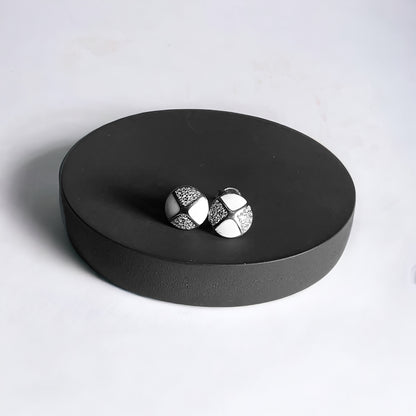 a pair of earrings sitting on top of a black box