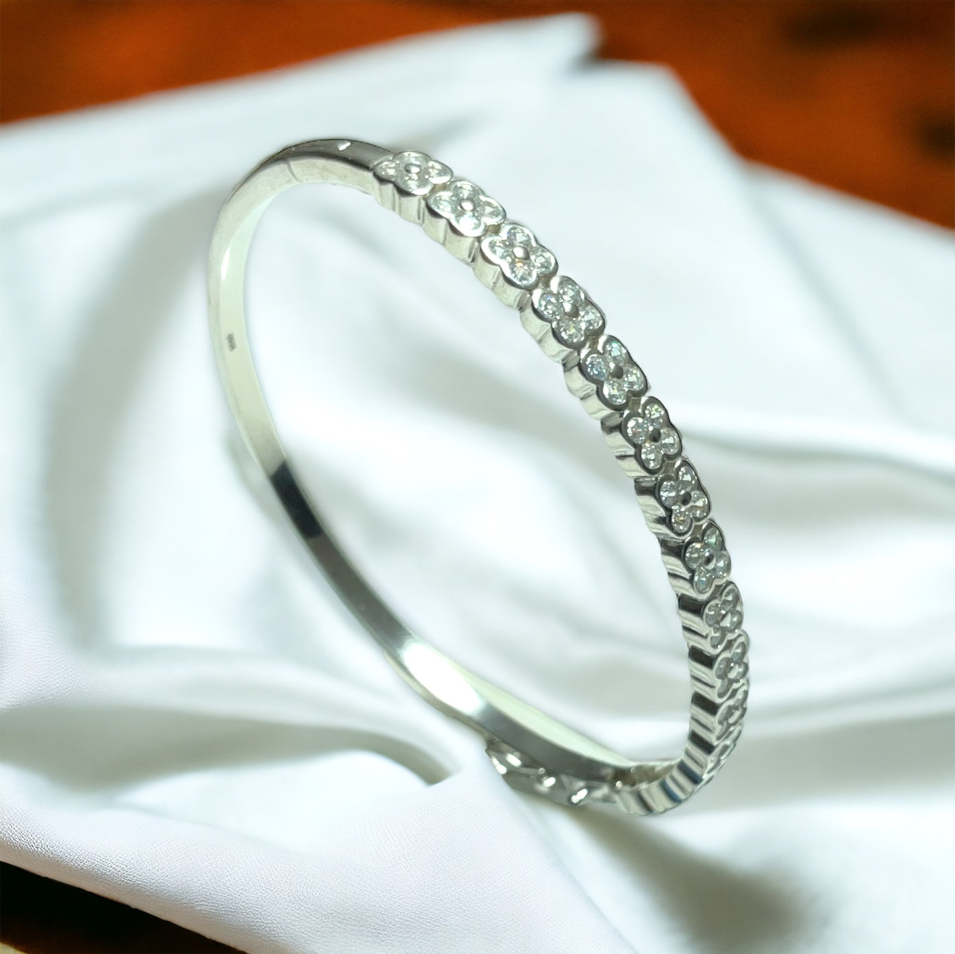 a close up of a silver bracelet on a white cloth