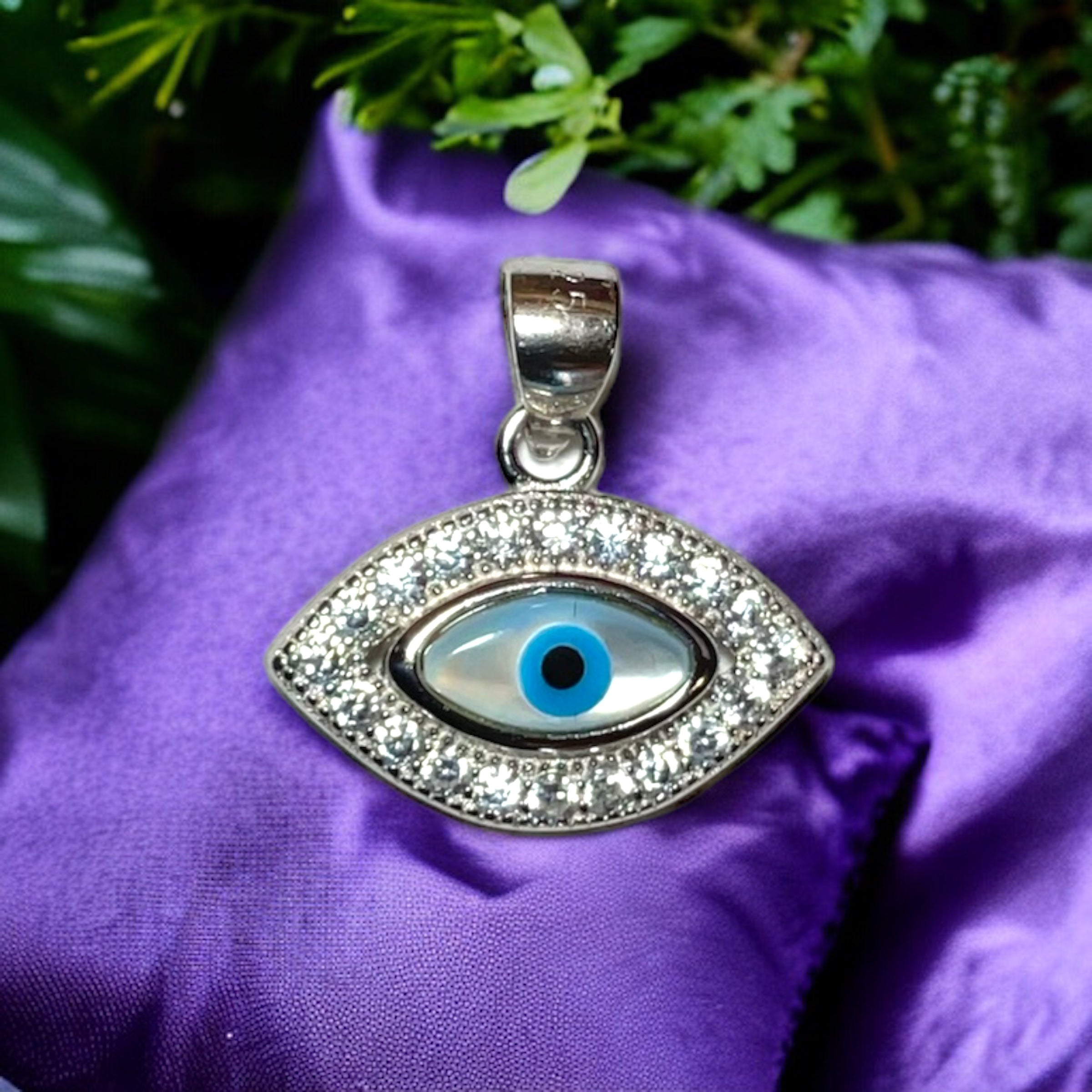 a purple cloth with a silver evil eye charm on it