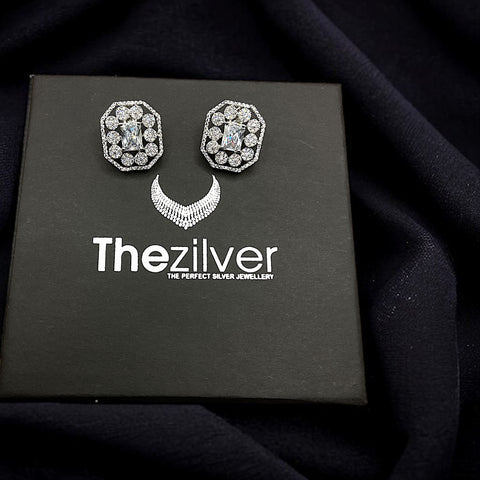 a pair of earrings sitting on top of a black box