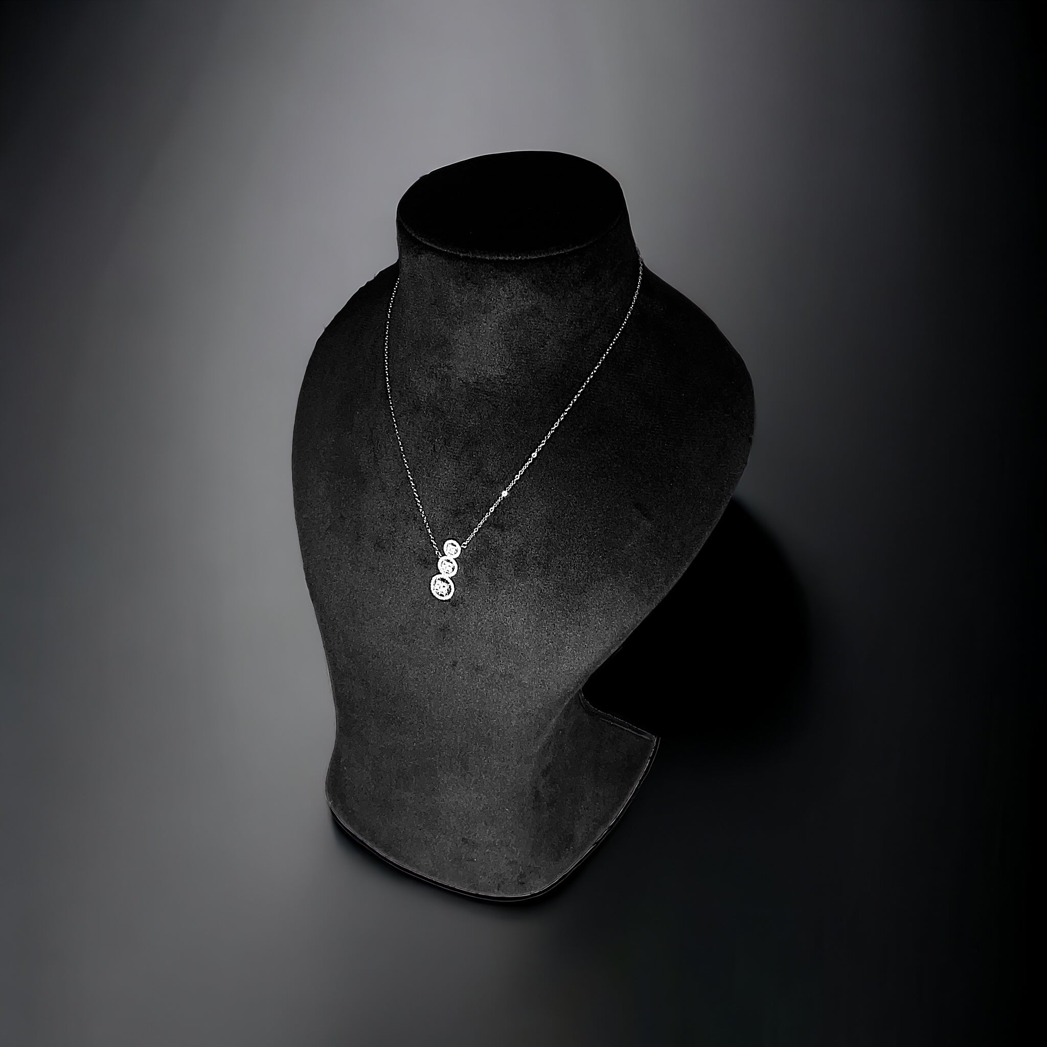 a necklace on a mannequin on a black background