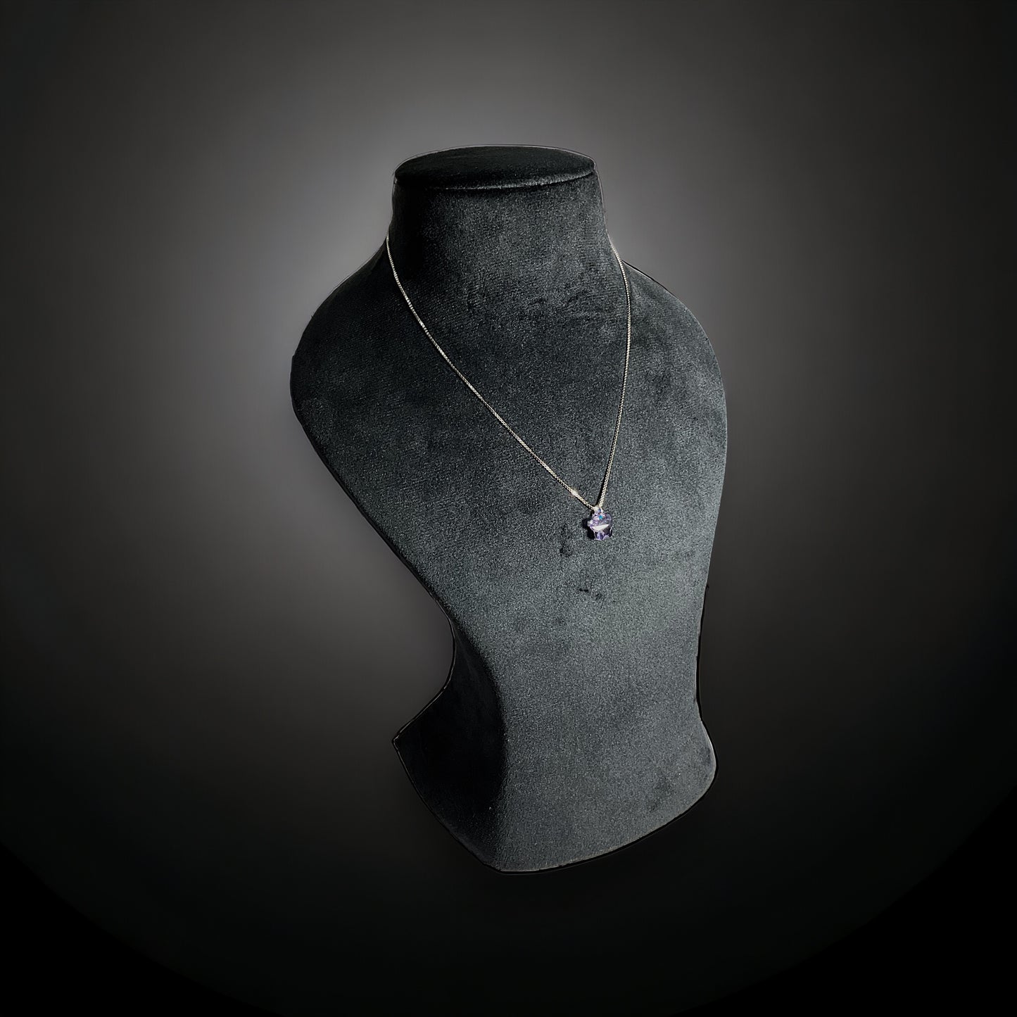 a necklace on a mannequin on a black background