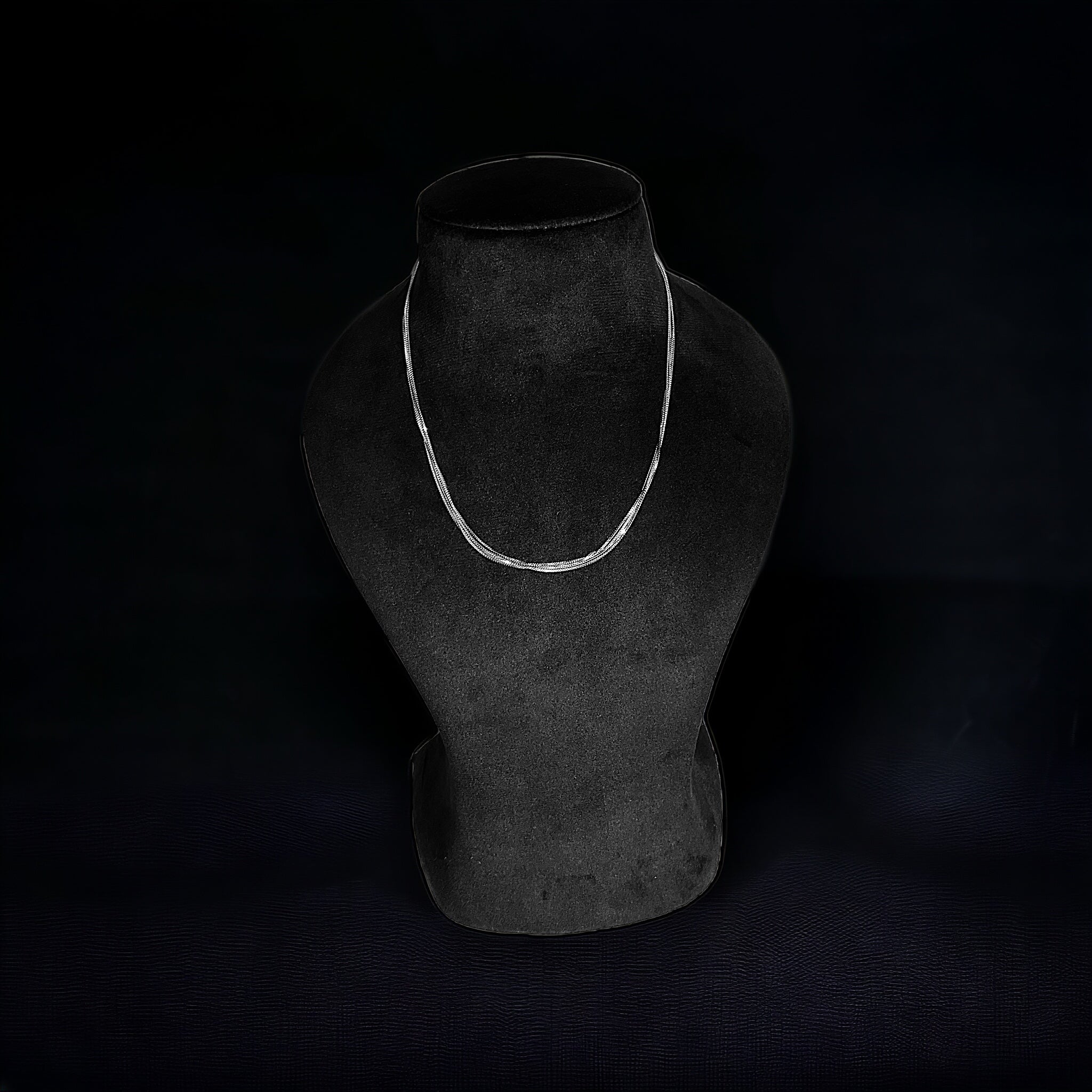 a black mannequin with a white necklace on it