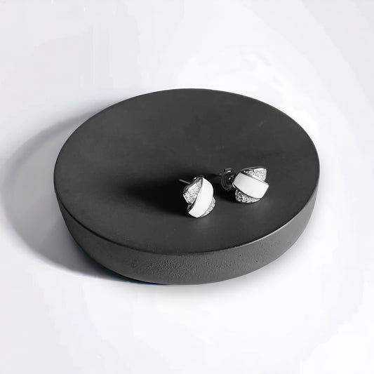 a pair of earrings sitting on top of a black plate