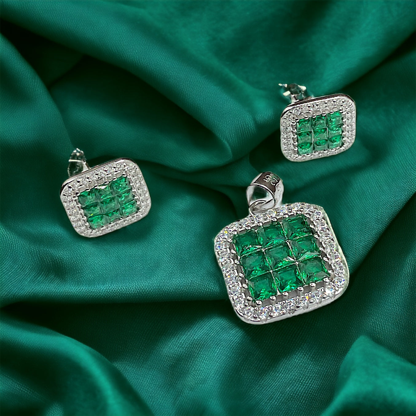 a pair of emerald and diamond earrings