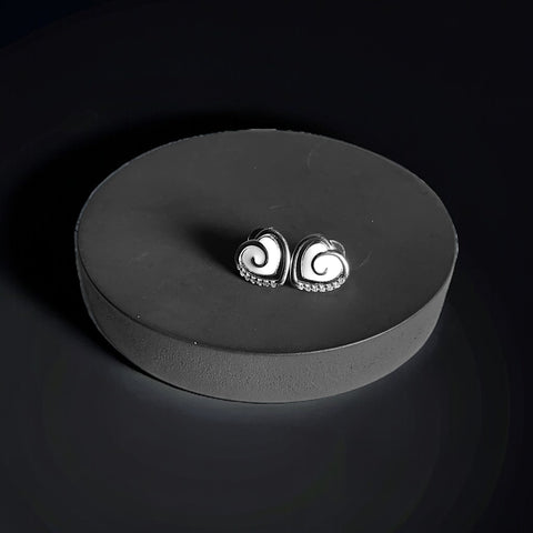 a pair of earrings sitting on top of a black plate