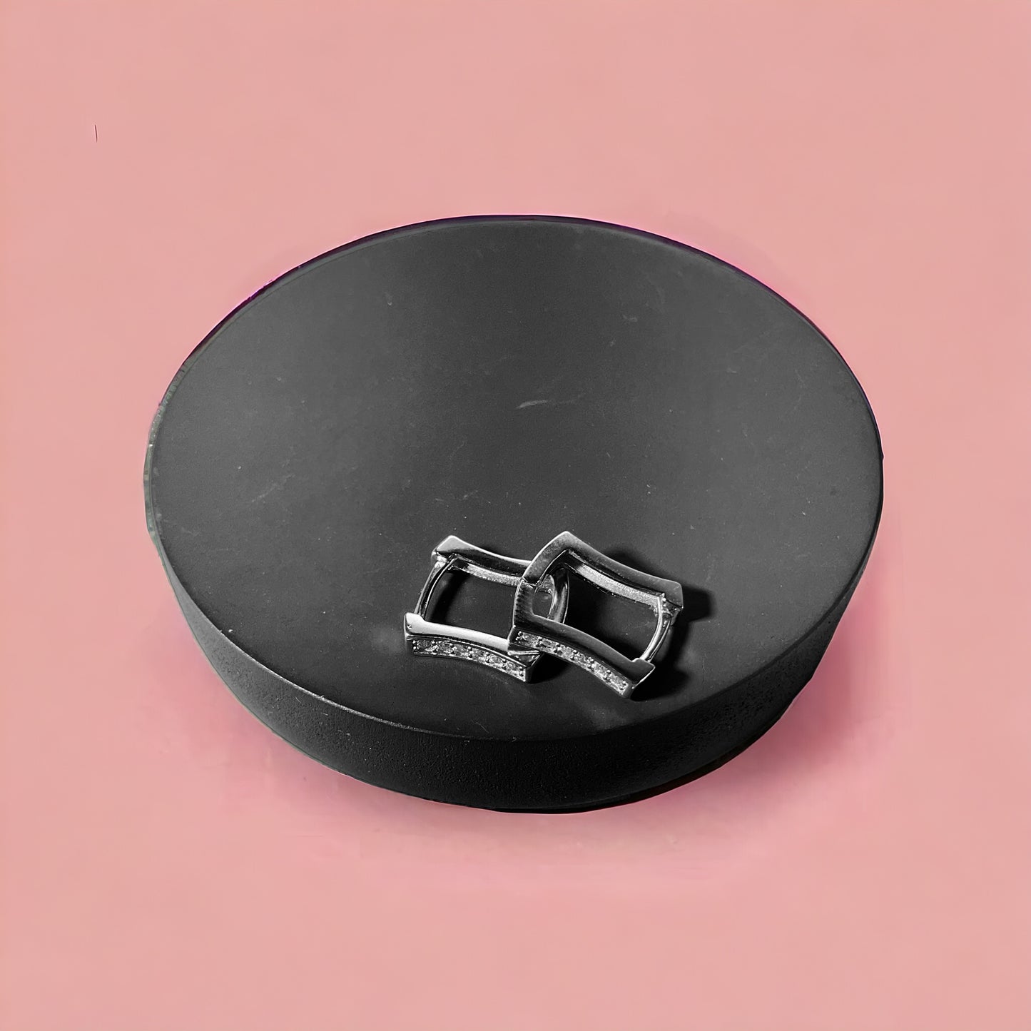 a pair of silver buckles sitting on top of a black case